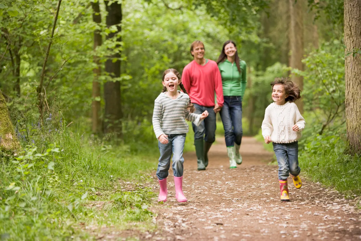 Family walking together through a wooded area